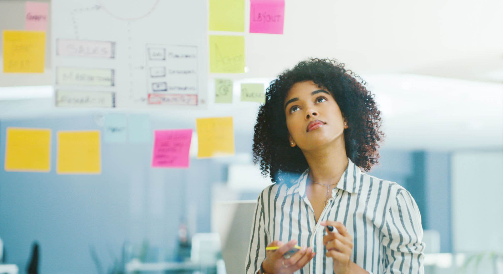 A woman curiously stares at project management board